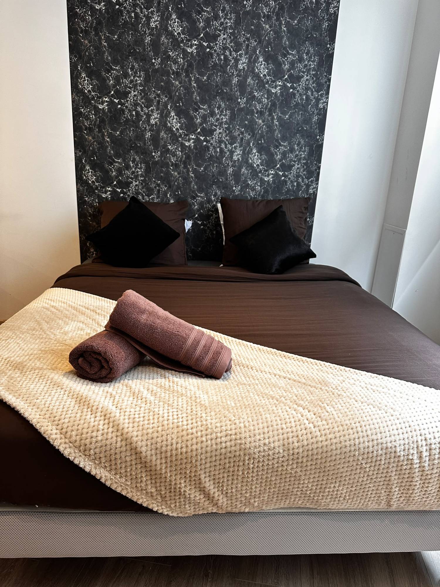 Lit double fait avec plaid et serviettes roulées, location courte durée à Arras, ménage BNB Cleaner